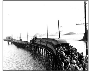 passengers flock to pier by train in late 1800s.